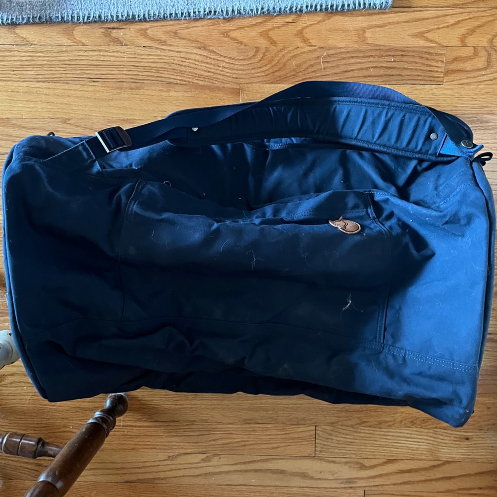Large navy blue Fjallraven duffel with backpack straps and many pockets